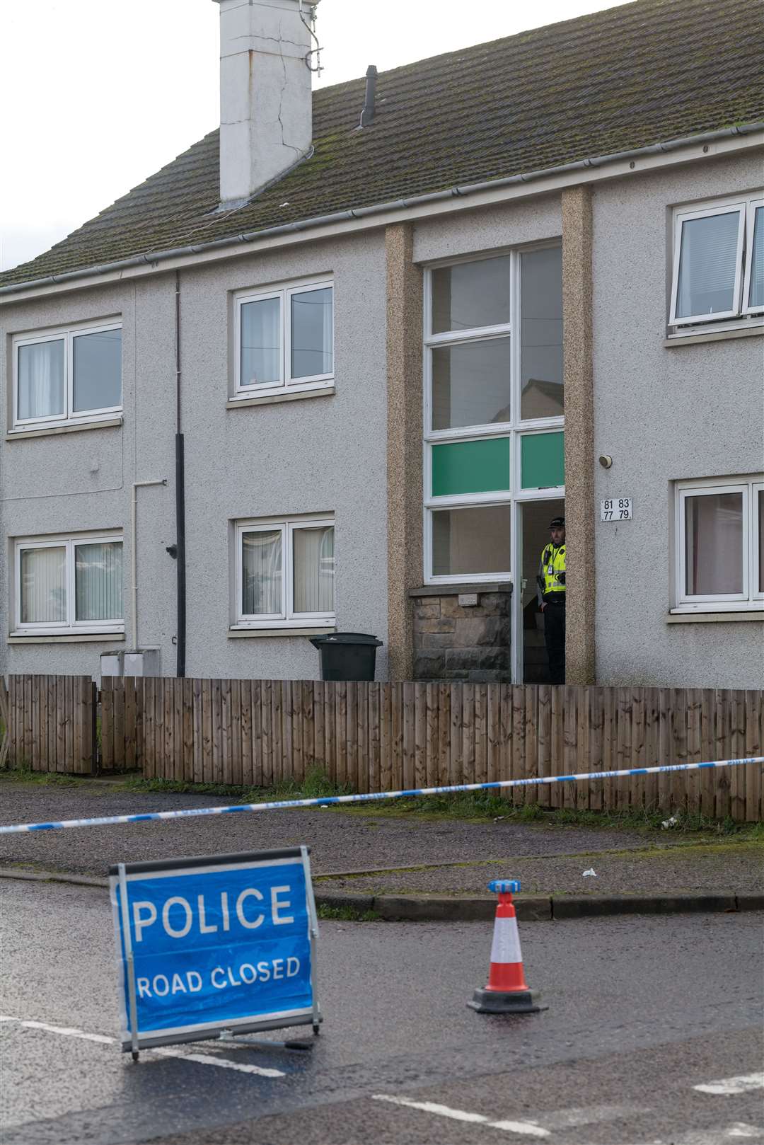 The area immediately around the small block of flats is cordoned off and guarded by a uniformed officer. Picture: Jasperimage