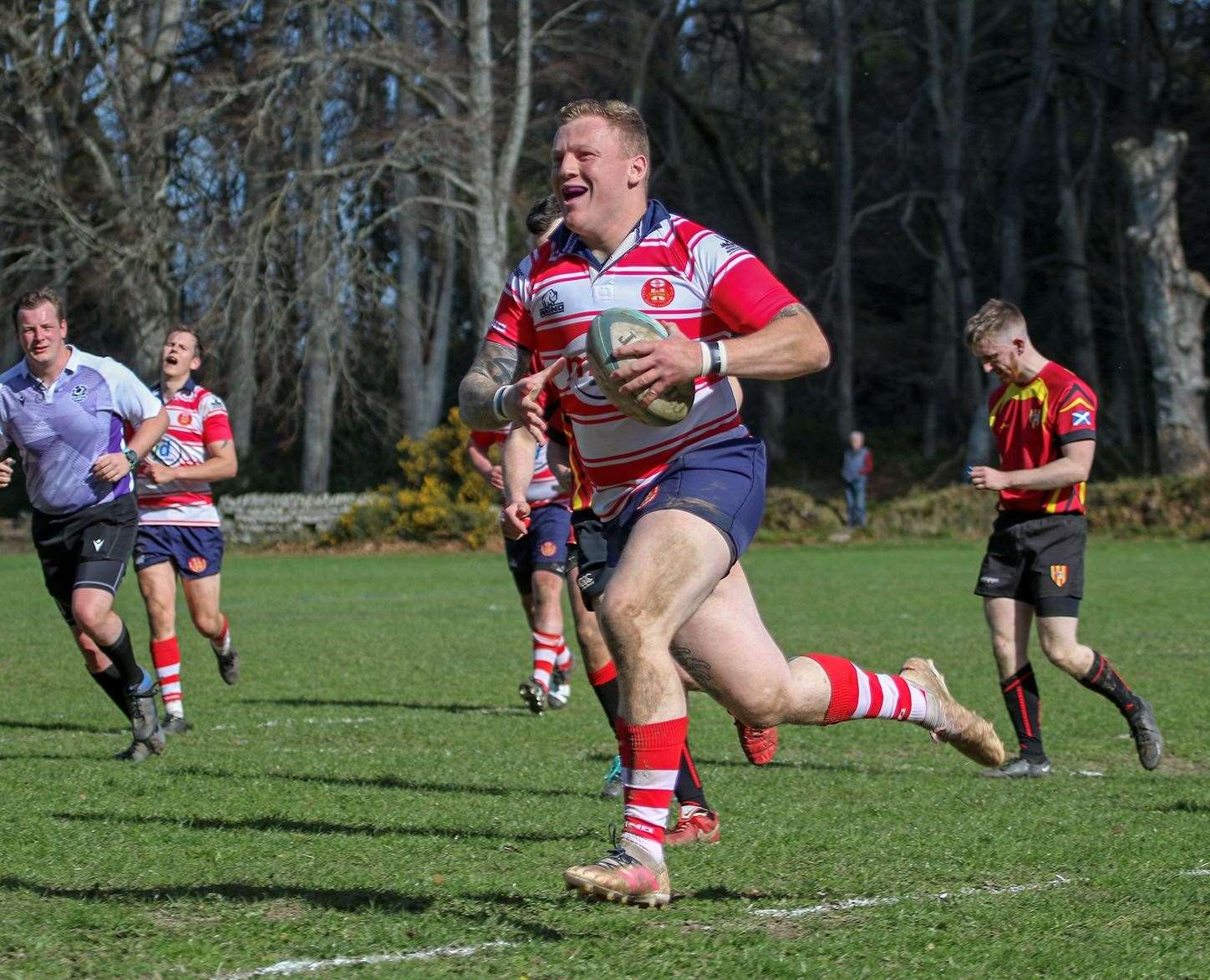 Lewis Scott smiles as he runs in try
