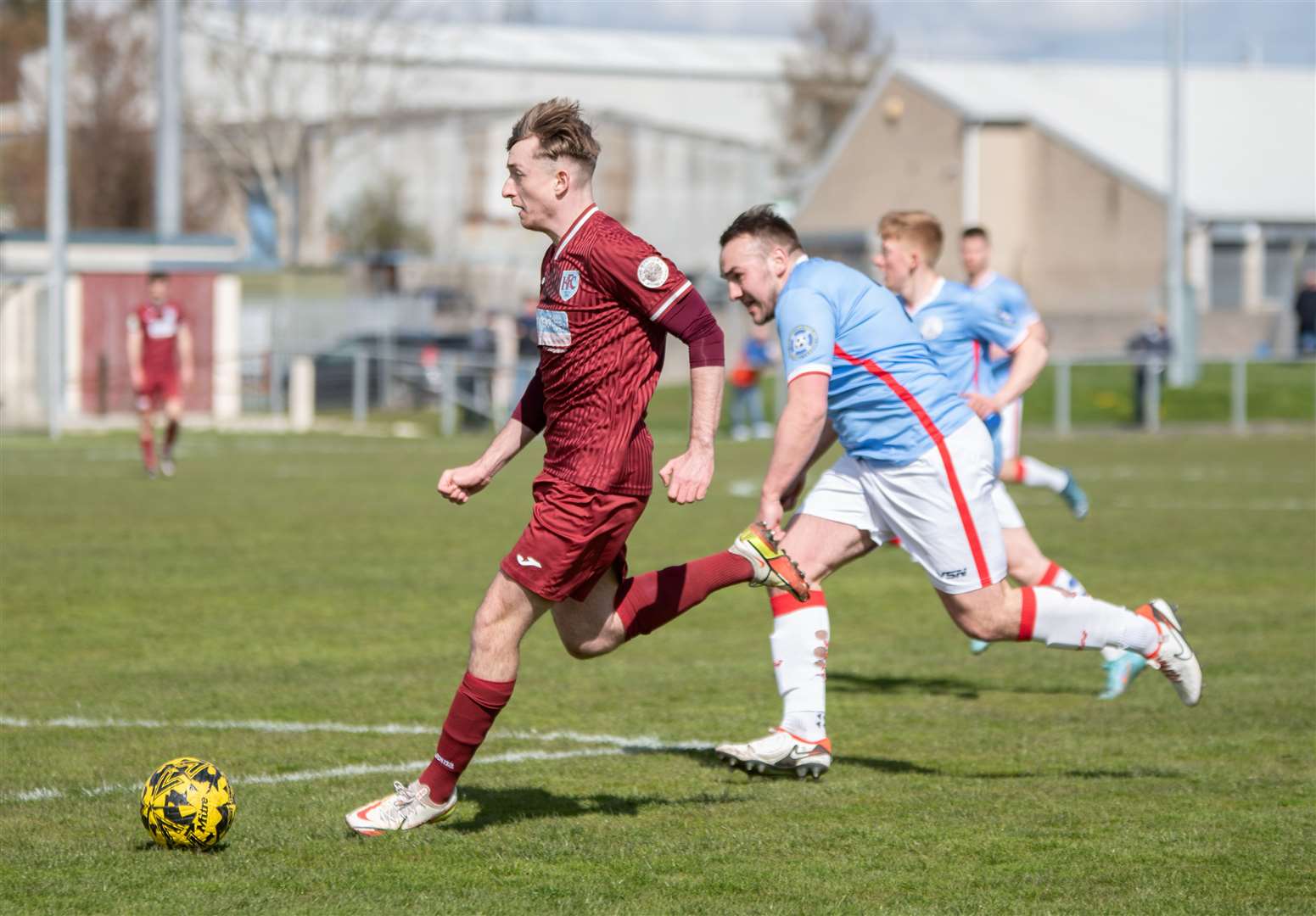 Keith's Jordan Lynch is tracked by Wick Academy's Owen Harrold as he looks for his next pass.Picture: Daniel Forsyth.